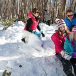 Family playing in the snow and Tobogganing at lake mountain
