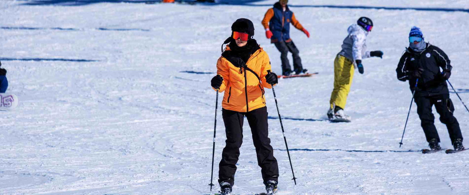 Woman in yellow jacket down hill skiing at Mt. Buller